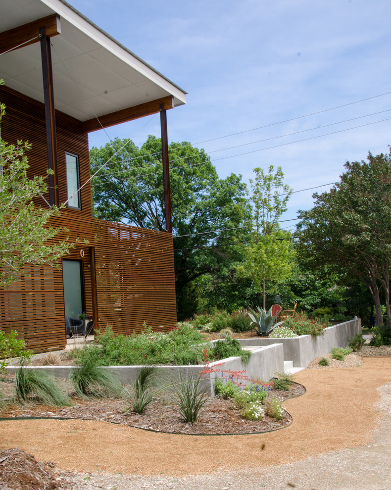 Стильный дизайн: солнечный засухоустойчивый сад среднего размера на переднем дворе в современном стиле с подпорной стенкой, хорошей освещенностью и мощением тротуарной плиткой - последний тренд