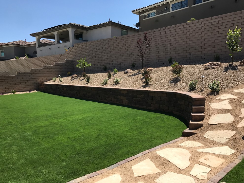 Design ideas for a large contemporary drought-tolerant and partial sun backyard concrete paver retaining wall landscape in Las Vegas for summer.