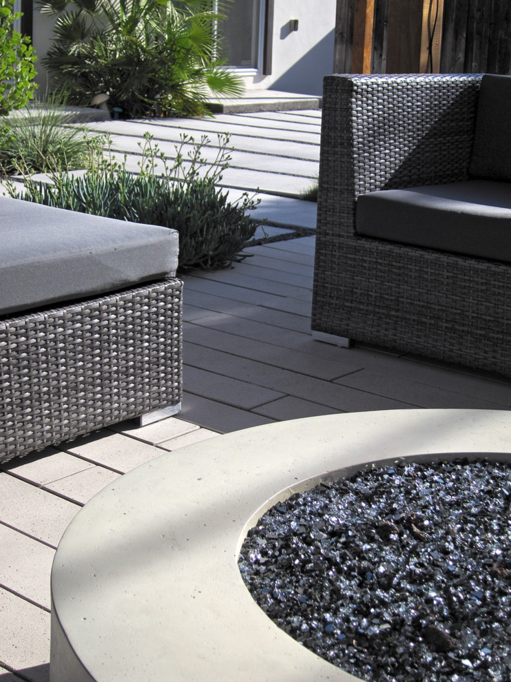 Design ideas for a mid-sized modern full sun backyard concrete paver landscaping in San Francisco with a fire pit.