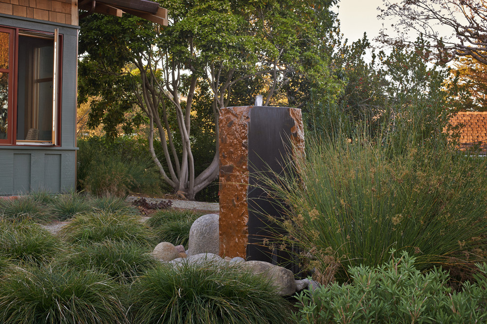 Imagen de jardín de secano de estilo americano grande en patio trasero con exposición total al sol, mantillo y fuente