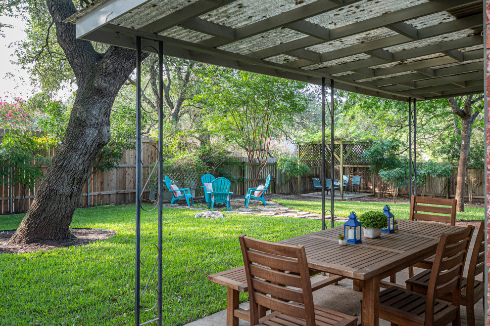 Transitional concrete patio photo in Austin with a pergola