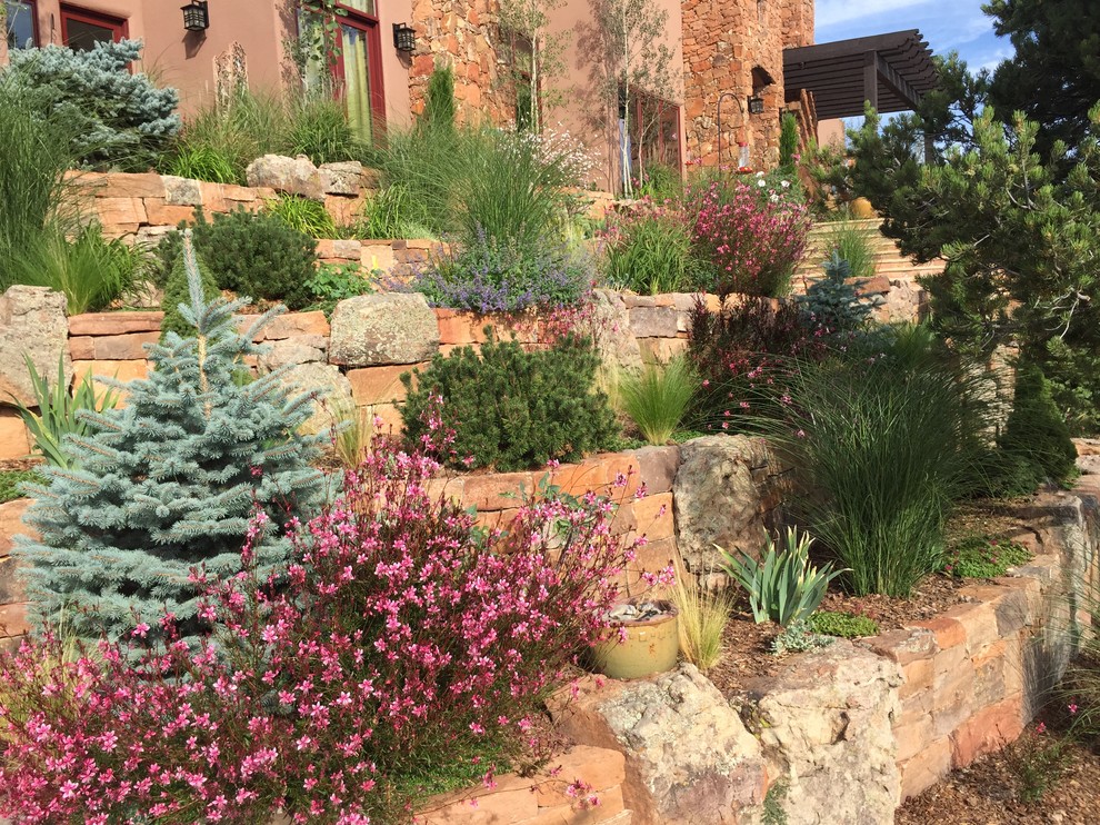 Imagen de camino de jardín ecléctico de tamaño medio en verano en patio delantero con jardín francés, exposición parcial al sol y adoquines de piedra natural