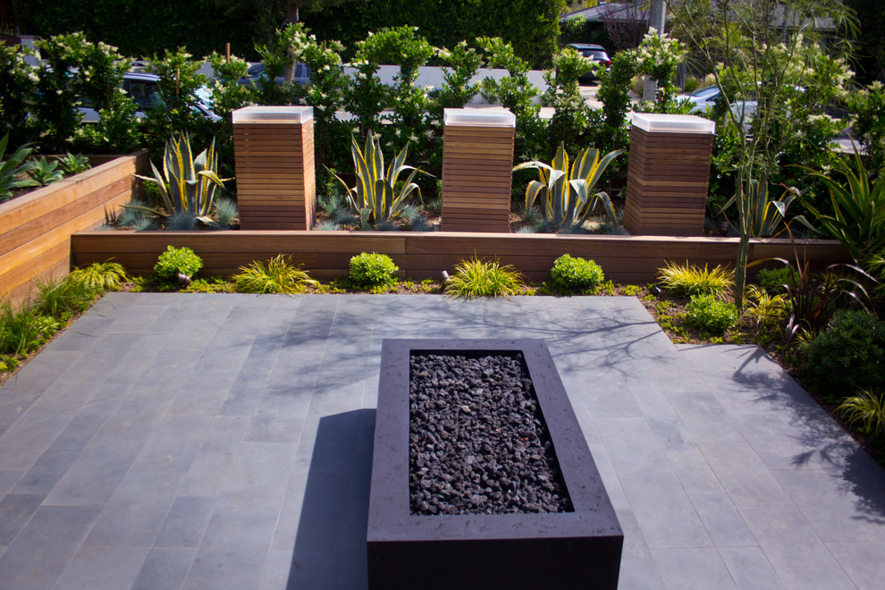 Esempio di un giardino xeriscape design esposto in pieno sole di medie dimensioni e davanti casa in estate con un focolare e pavimentazioni in pietra naturale