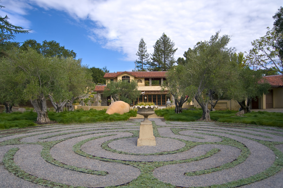 This is an example of a mediterranean backyard gravel water fountain landscape in San Francisco.