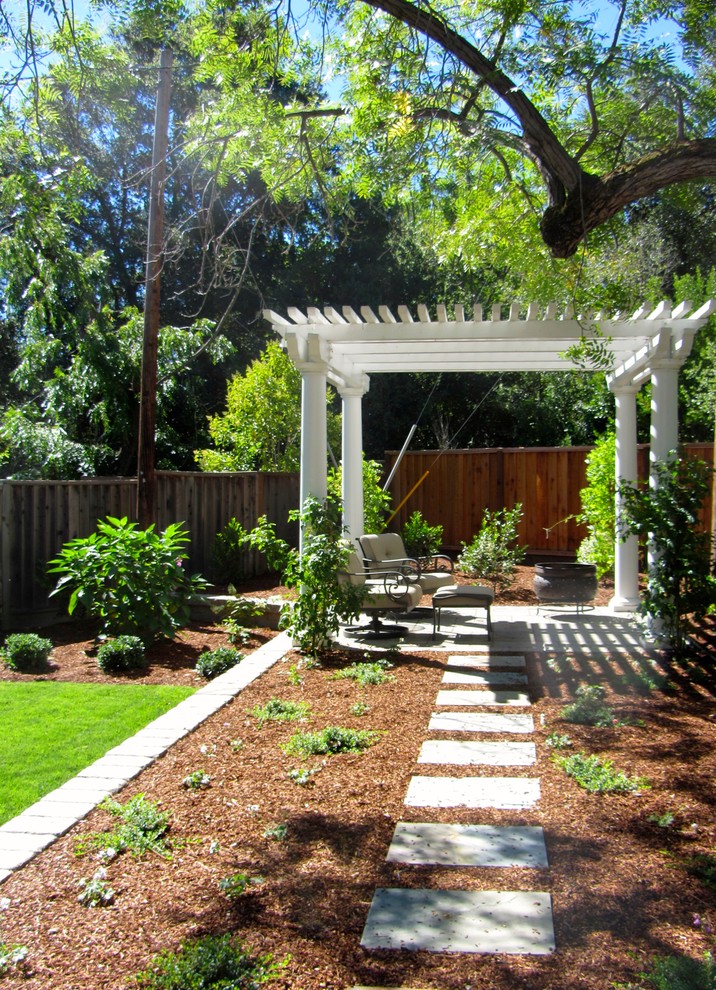 Diseño de jardín clásico renovado de tamaño medio en patio trasero con muro de contención, exposición total al sol y adoquines de hormigón