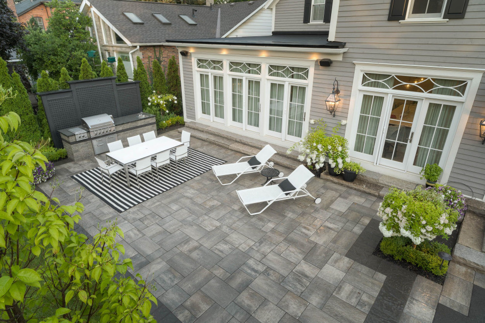 Immagine di un grande patio o portico minimal dietro casa con pavimentazioni in pietra naturale