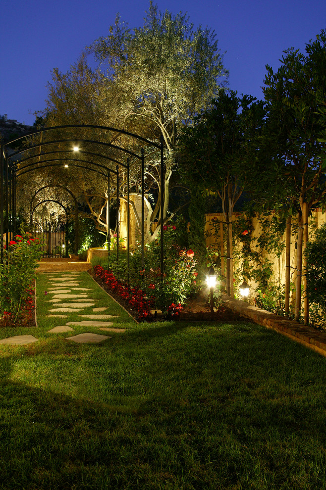 Halbschattiger, Geometrischer, Mittelgroßer Mediterraner Garten neben dem Haus, im Frühling mit Natursteinplatten und Gehweg in Orange County