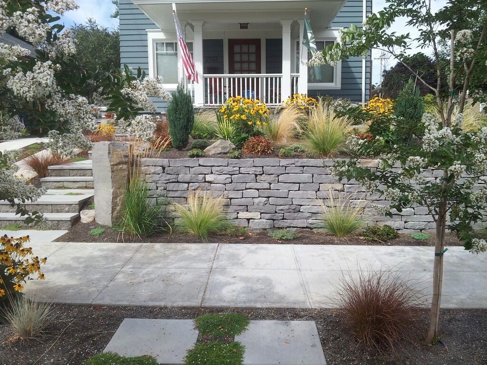 This is an example of a mid-sized traditional partial sun front yard stone landscaping in Portland.