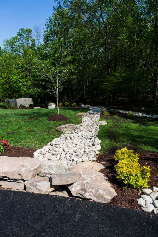 This is an example of a huge rustic full sun front yard stone landscaping in DC Metro.