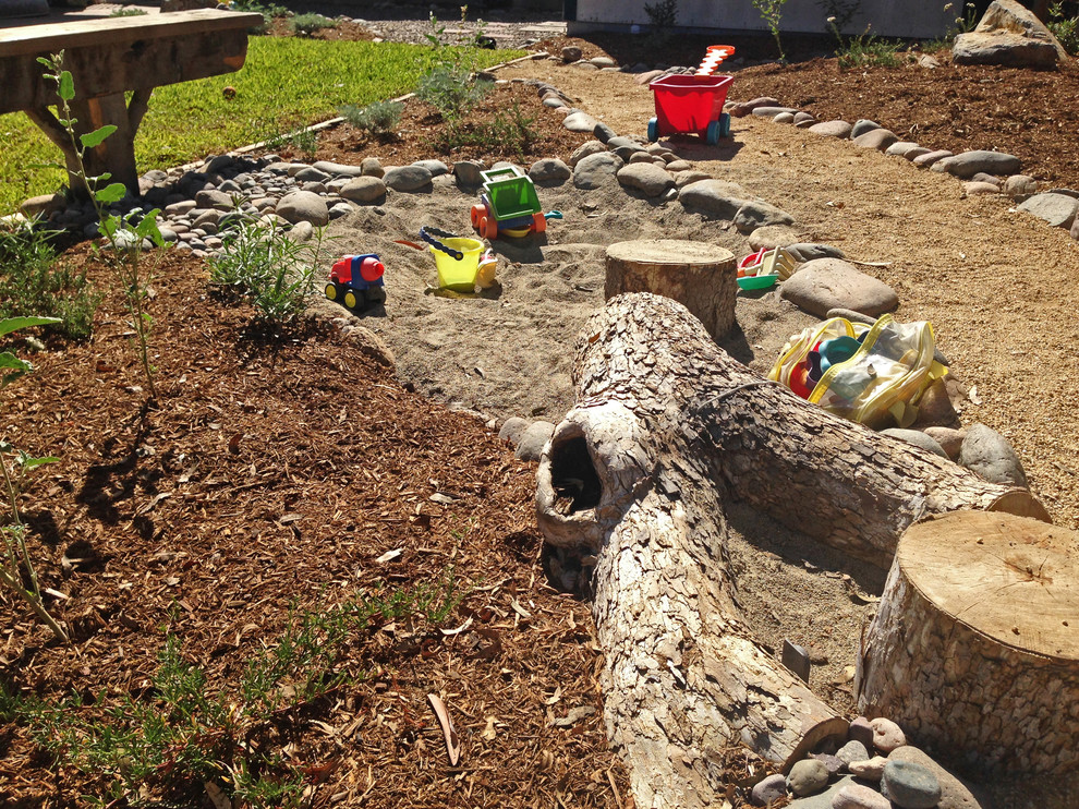 На фото: солнечный засухоустойчивый сад среднего размера на заднем дворе в средиземноморском стиле с детским городком, хорошей освещенностью и покрытием из гравия с