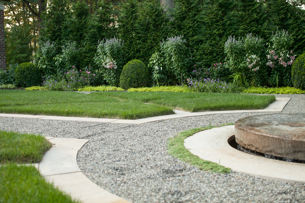 Cette image montre un aménagement d'entrée ou allée de jardin latéral traditionnel l'été et de taille moyenne avec une exposition ensoleillée et du gravier.
