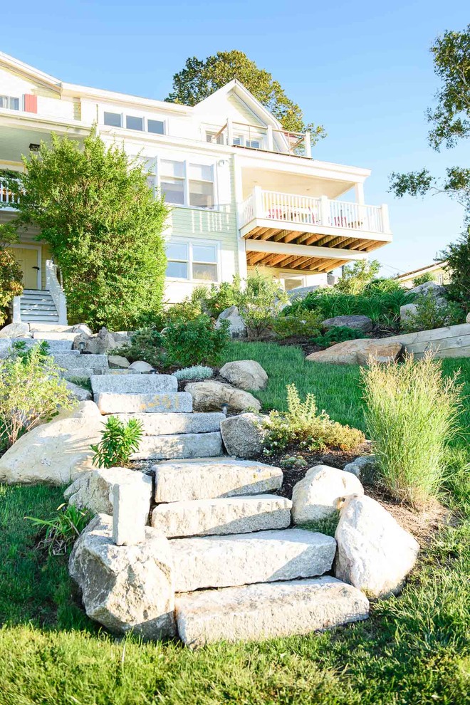 Immagine di un grande giardino stile marinaro esposto a mezz'ombra con un muro di contenimento, un pendio, una collina o una riva e pavimentazioni in pietra naturale