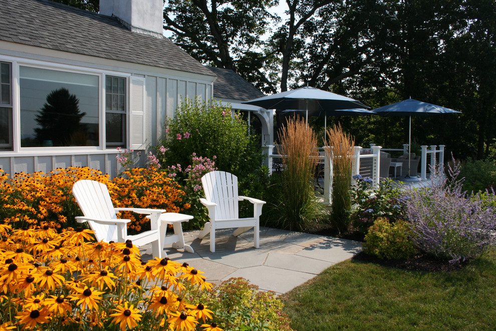 На фото: солнечный, летний участок и сад среднего размера на переднем дворе в морском стиле с хорошей освещенностью и покрытием из каменной брусчатки