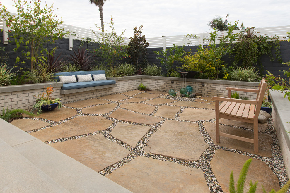 Design ideas for a mid-sized transitional partial sun backyard concrete paver formal garden in Los Angeles with a fire pit for summer.