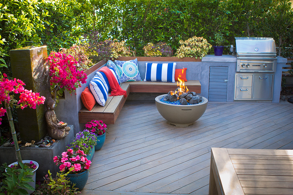 Inspiration for a small traditional front yard landscaping in Orange County with a fire pit and decking.