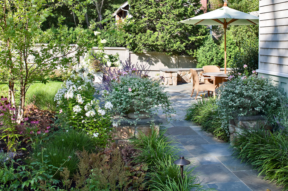 Bild på en vintage trädgård på sommaren, med utekrukor och naturstensplattor