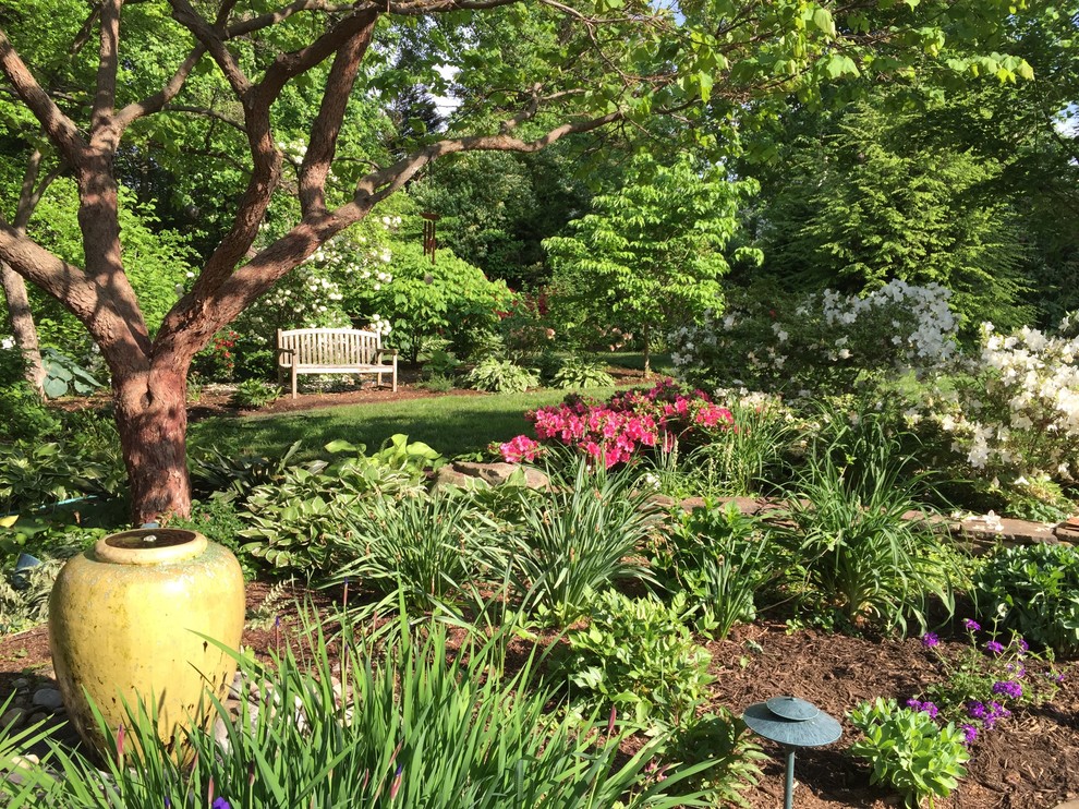 Immagine di un piccolo giardino formale classico esposto a mezz'ombra dietro casa in primavera con pavimentazioni in pietra naturale