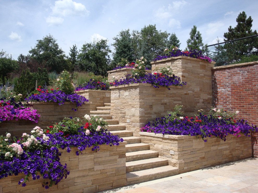 Inspiration for a mid-sized contemporary full sun backyard stone retaining wall landscape in Denver for summer.