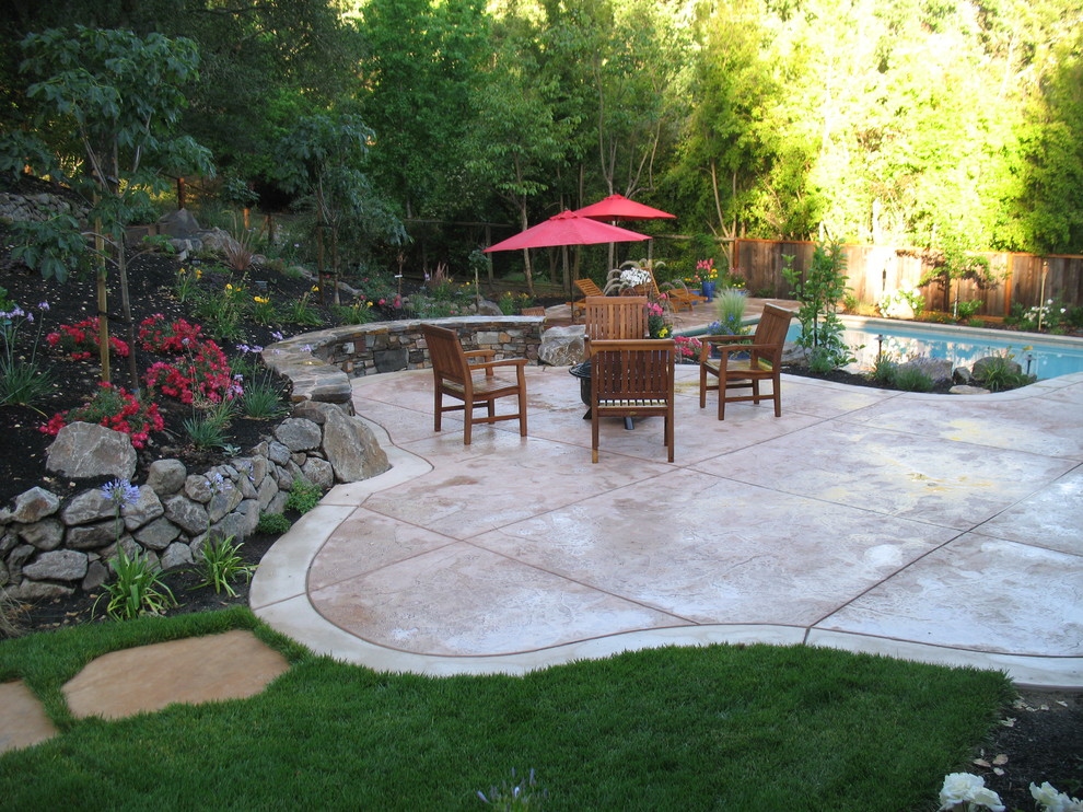 Foto de jardín tradicional grande en patio trasero con muro de contención, exposición parcial al sol y adoquines de piedra natural