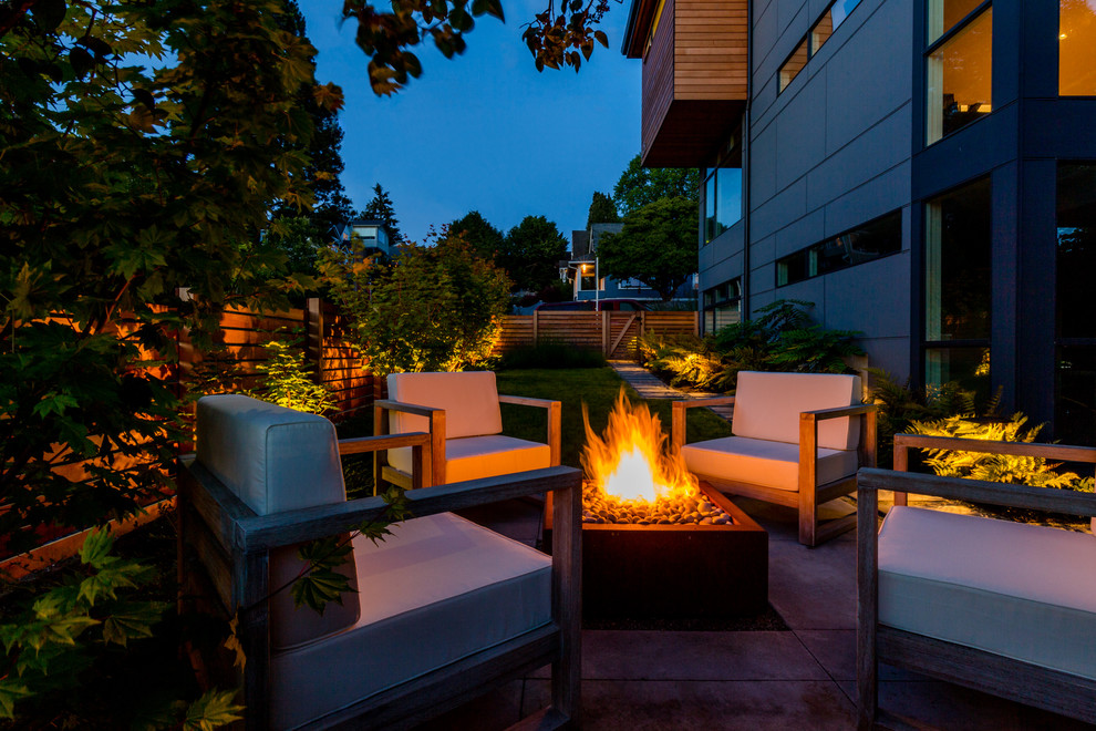 Kleiner, Halbschattiger Moderner Garten hinter dem Haus mit Feuerstelle und Betonboden in Seattle