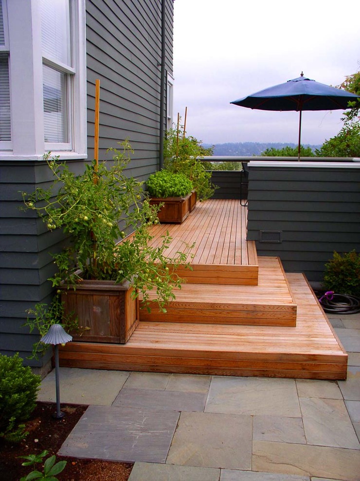 This is an example of a mid-sized contemporary full sun backyard landscaping in Seattle with decking.