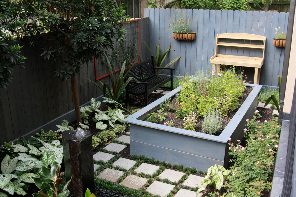 Idéer för att renovera en liten eklektisk trädgård i delvis sol, med en fontän och marksten i betong