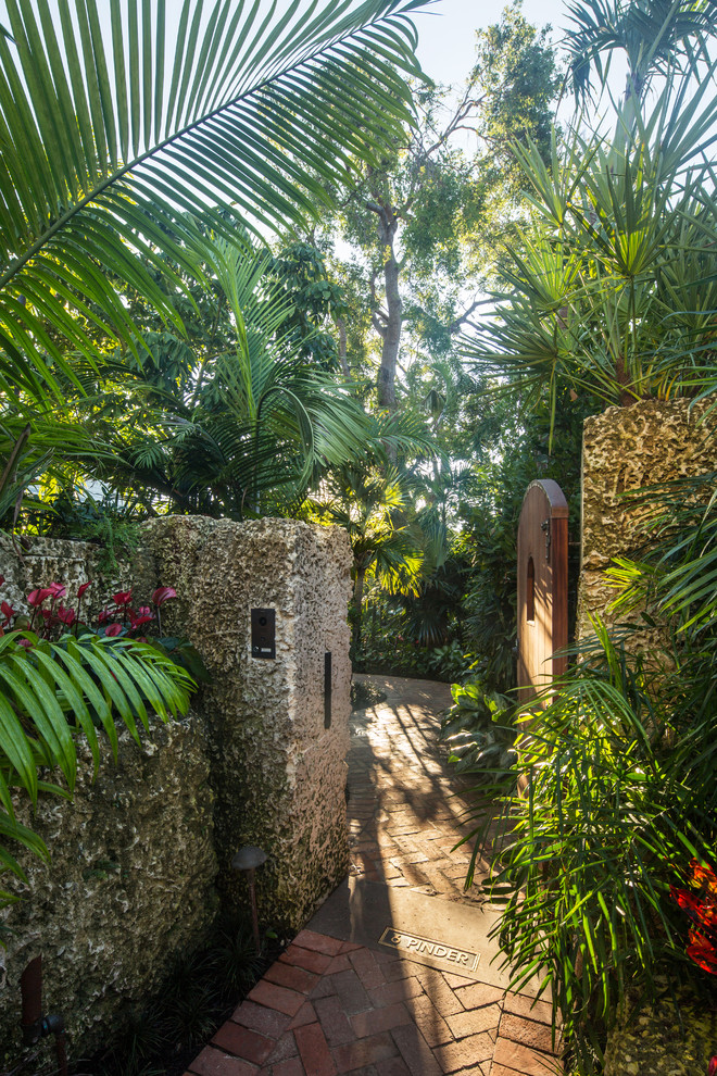Foto di un giardino tropicale esposto in pieno sole di medie dimensioni e davanti casa con pavimentazioni in mattoni