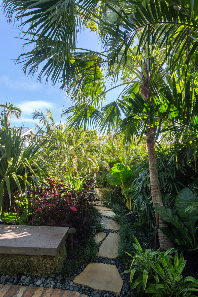 Mittelgroßer Garten neben dem Haus mit direkter Sonneneinstrahlung und Pflastersteinen in Miami