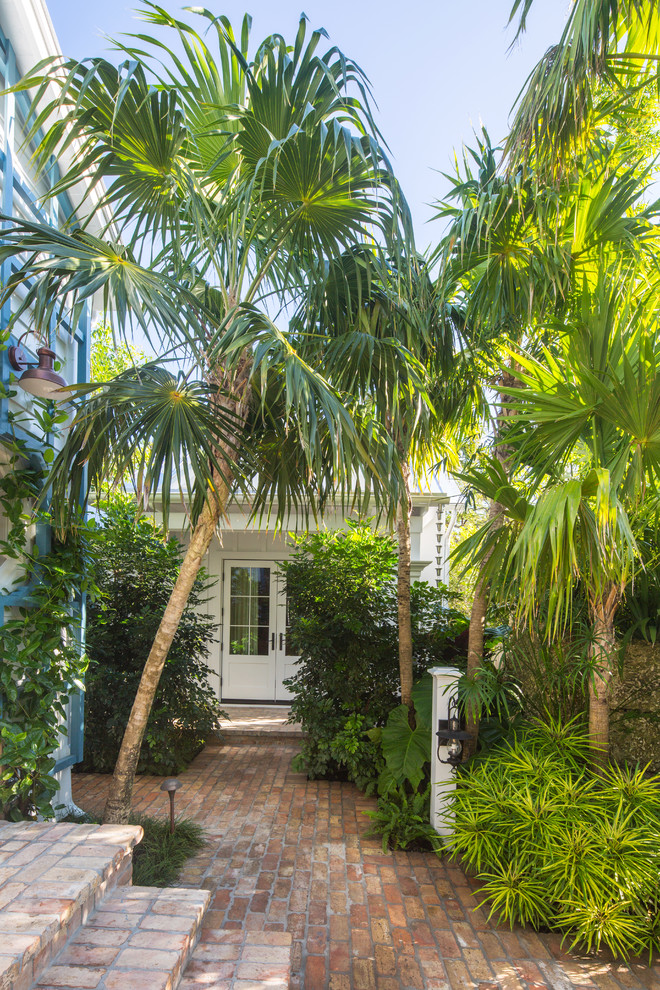 Inspiration for a mid-sized tropical full sun side yard brick landscaping in Miami.