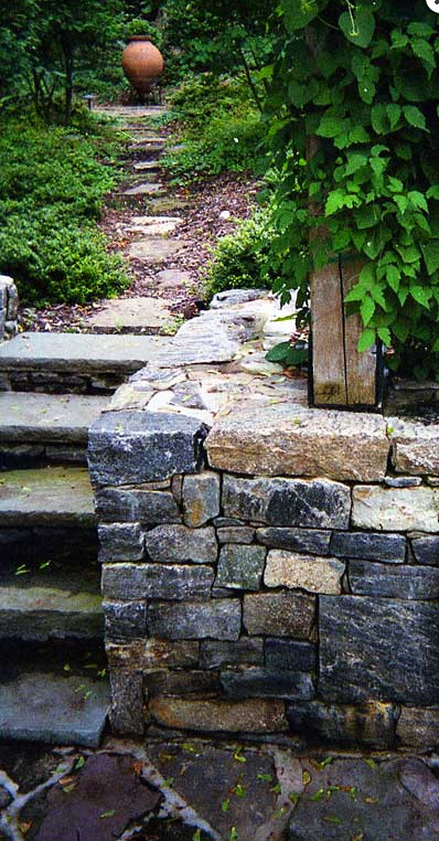 This is an example of a mid-sized traditional hillside stone garden path in New York.