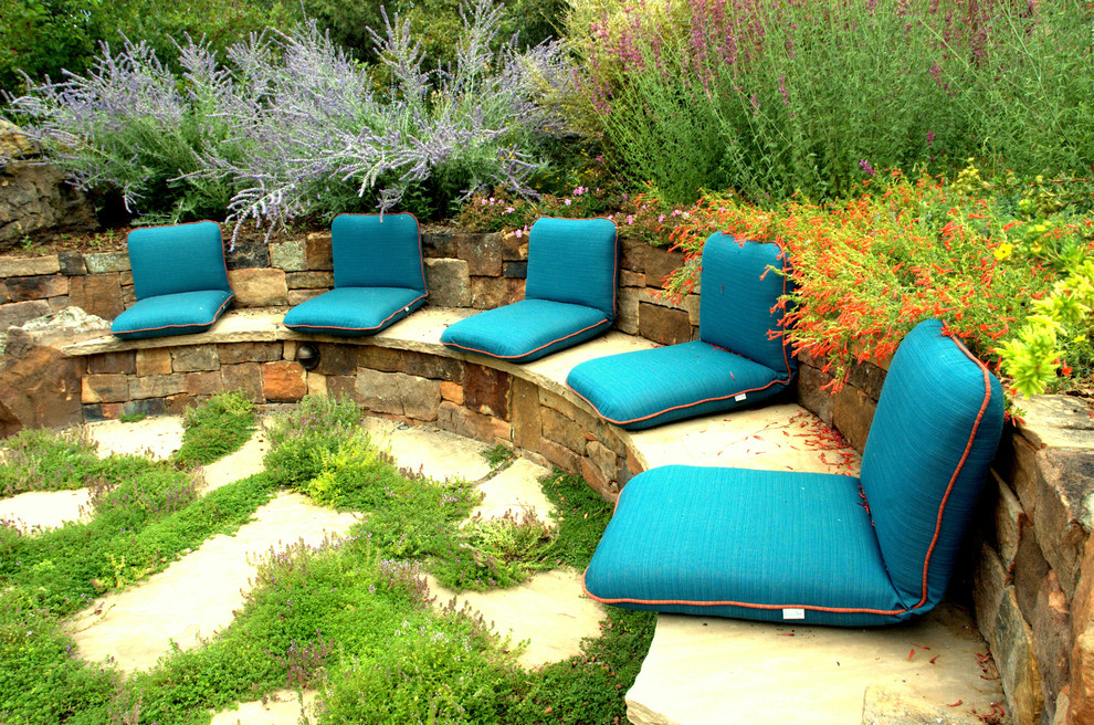 Пример оригинального дизайна: большой солнечный участок и сад на заднем дворе в стиле фьюжн с подпорной стенкой и хорошей освещенностью
