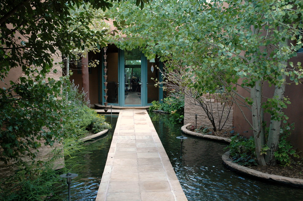 Inspiration for a large contemporary courtyard partial sun garden for summer in Albuquerque with a garden path and natural stone paving.