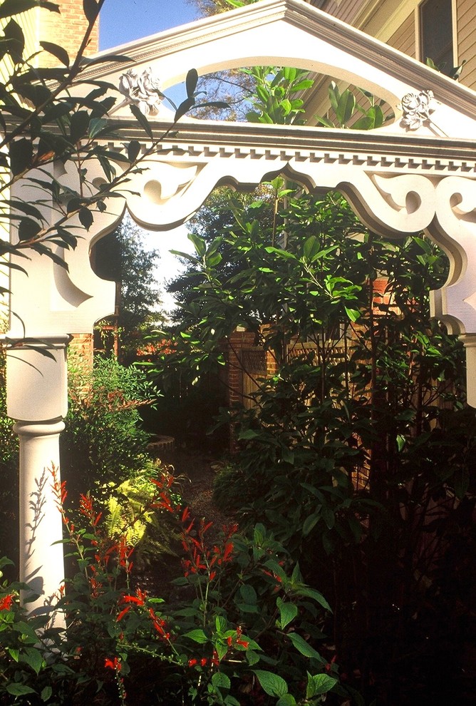 Immagine di un grande giardino formale eclettico esposto a mezz'ombra nel cortile laterale in primavera con fontane e pavimentazioni in mattoni