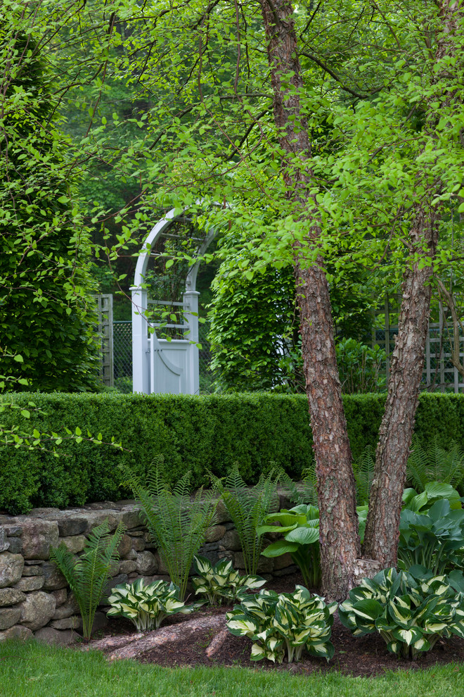 Imagen de jardín tradicional de tamaño medio en patio trasero con jardín francés y exposición parcial al sol