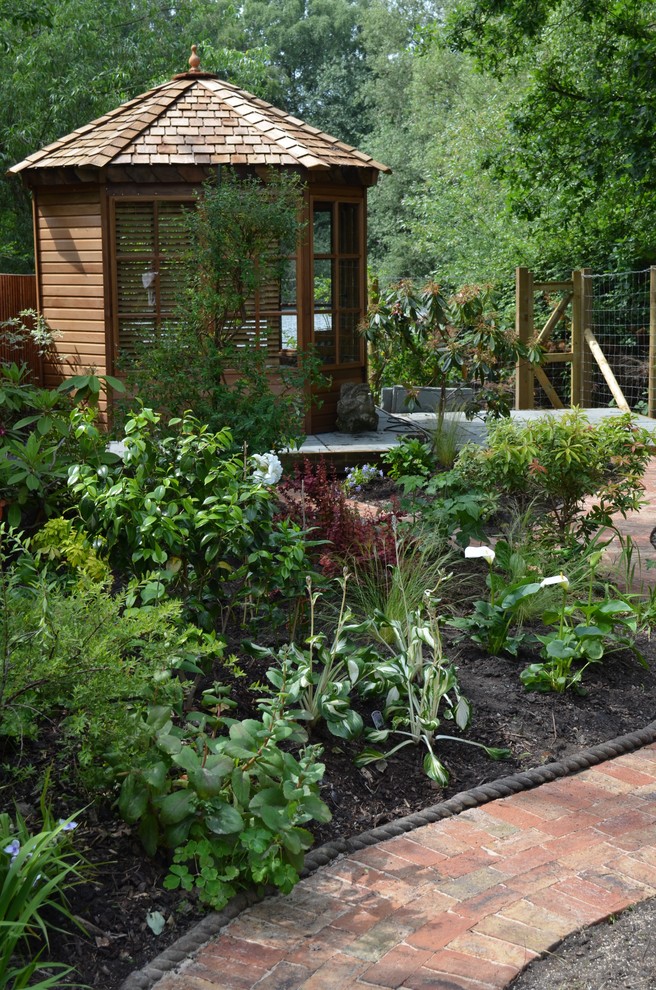 This is an example of a small classic back fully shaded garden for summer in Surrey.