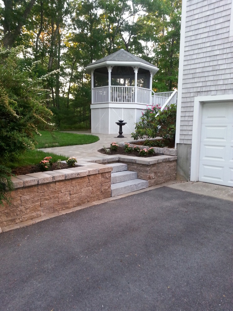 Imagen de acceso privado tradicional de tamaño medio en patio delantero con exposición parcial al sol y adoquines de piedra natural