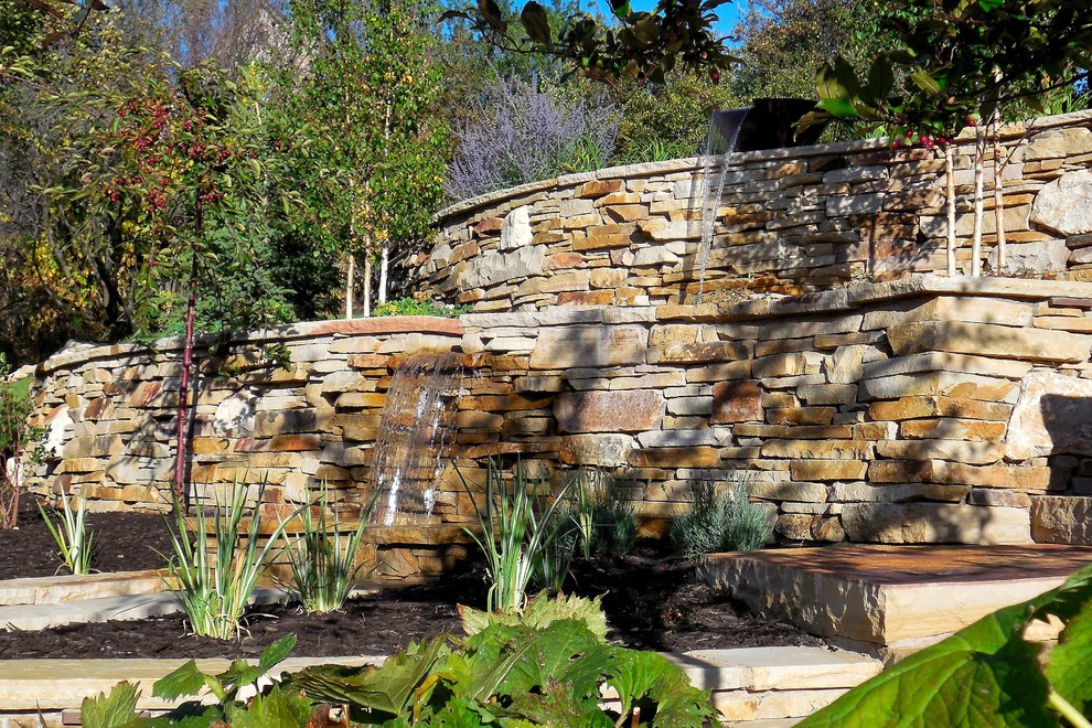 Aménagement d'un jardin classique de taille moyenne avec un point d'eau, une exposition partiellement ombragée, une pente, une colline ou un talus et des pavés en pierre naturelle.