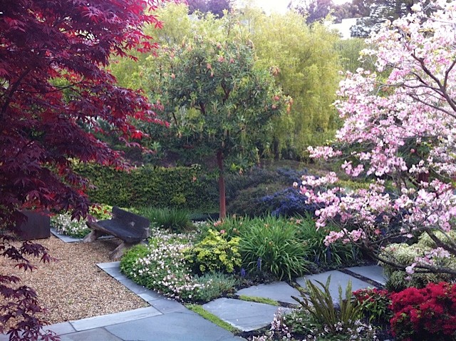 Foto di un'aiuola classica esposta a mezz'ombra davanti casa in primavera con graniglia di granito