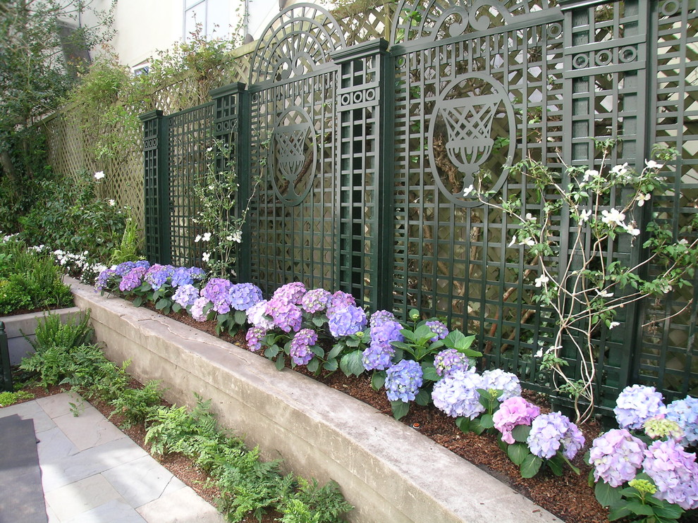 Aménagement d'un jardin classique avec un mur de soutènement.