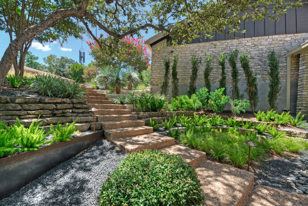 Idee per un grande giardino xeriscape minimalista in ombra dietro casa in primavera con un muro di contenimento e ghiaia