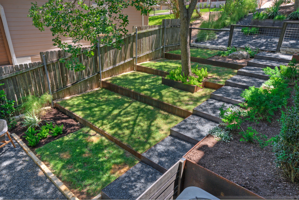 Inspiration för en stor funkis bakgård i skuggan som tål torka på våren, med en stödmur och grus