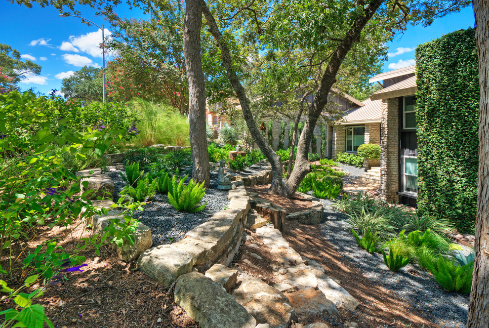Design ideas for a large drought-tolerant and shade front yard gravel retaining wall landscape in Austin for spring.