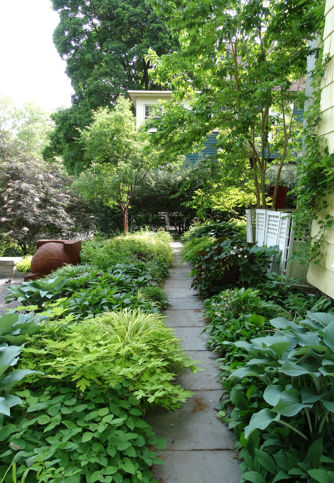 На фото: большой летний регулярный сад на боковом дворе в классическом стиле с садовой дорожкой или калиткой, полуденной тенью и покрытием из гравия