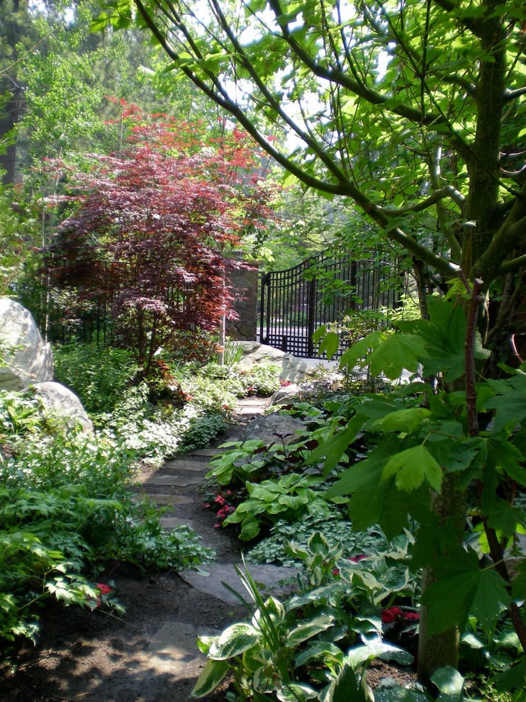 Photo of a mid-sized eclectic partial sun side yard stone formal garden in Other for summer.
