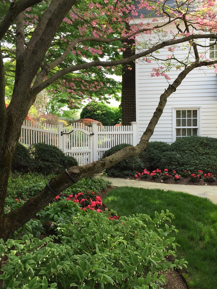 Foto di un grande giardino classico in ombra dietro casa in primavera con un ingresso o sentiero e pavimentazioni in pietra naturale