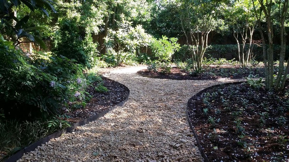 Photo of a large traditional shade backyard gravel landscaping in New Orleans.
