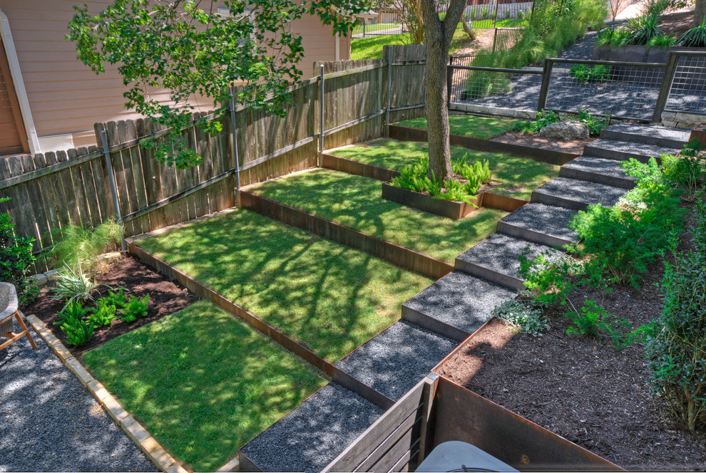 Источник вдохновения для домашнего уюта: большой тенистый, весенний засухоустойчивый сад на переднем дворе в современном стиле с подпорной стенкой и покрытием из гравия