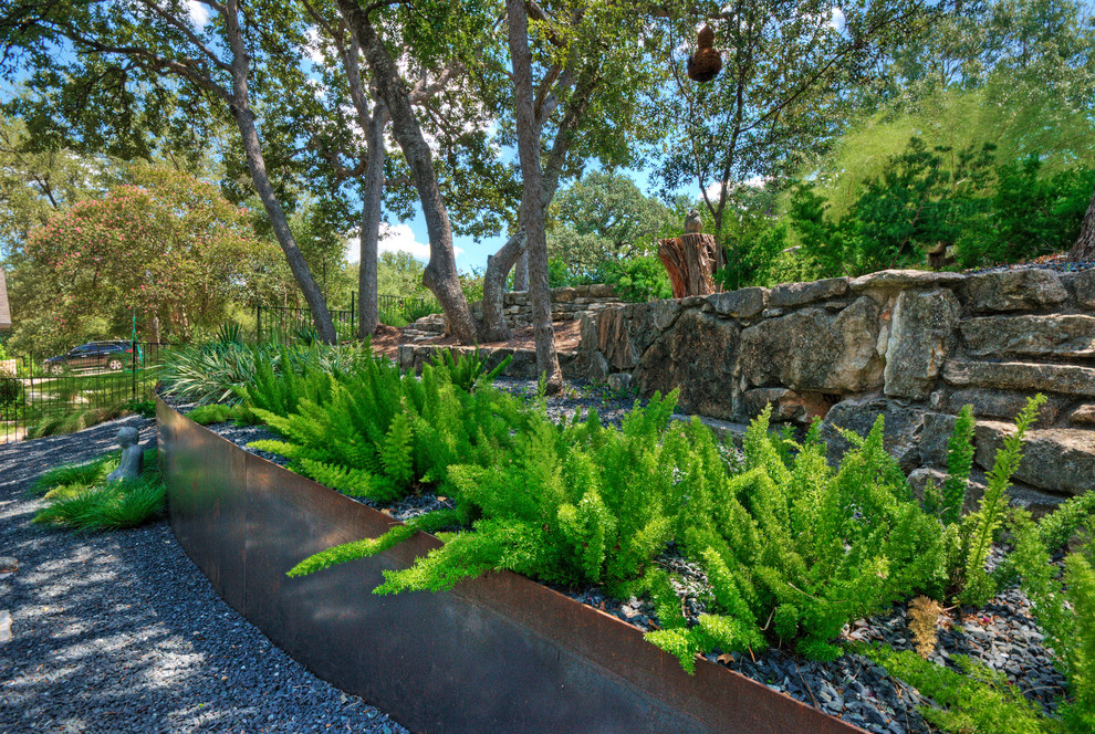 Idee per un grande giardino xeriscape moderno in ombra davanti casa in primavera con un muro di contenimento e ghiaia