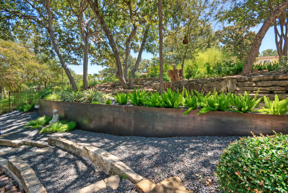 Идея дизайна: большой тенистый, весенний засухоустойчивый сад на переднем дворе в стиле модернизм с подпорной стенкой и покрытием из гравия