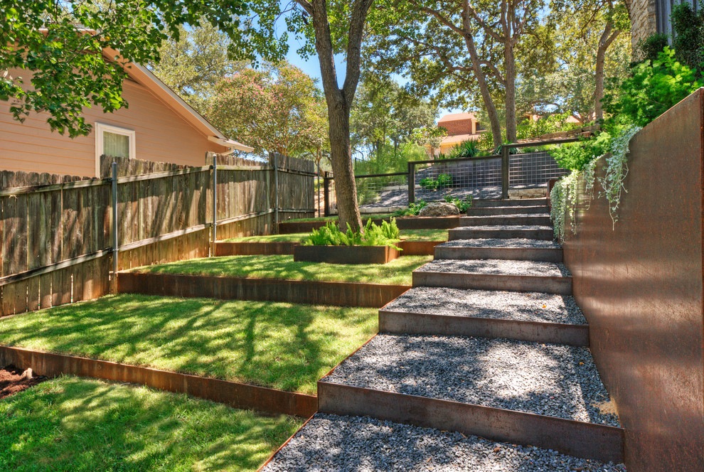 Idee per un grande giardino xeriscape design in ombra davanti casa in primavera con un muro di contenimento e ghiaia